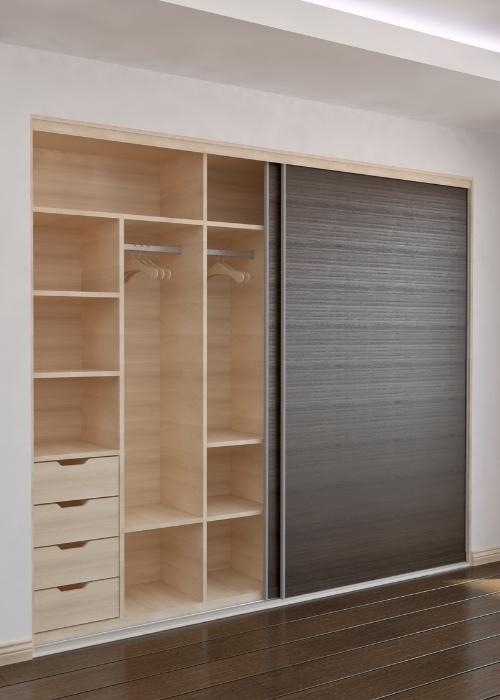 Armario empotrado a medida con puertas correderas y estantes de madera