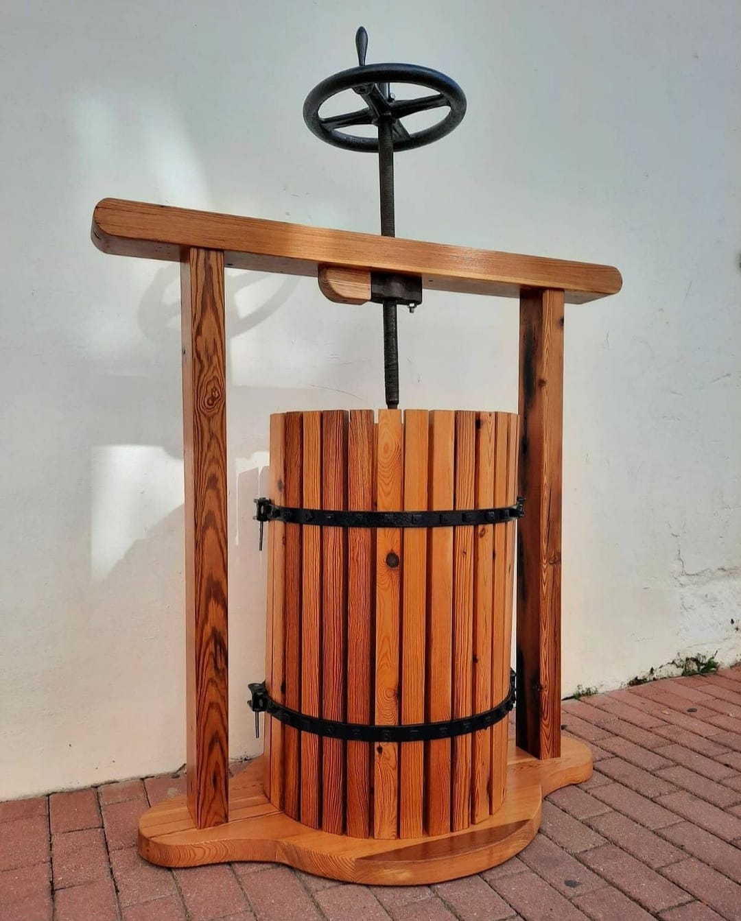 Prensa tradicional de madera artesanal para frutas o vino, mostrando técnicas de carpintería tradicional